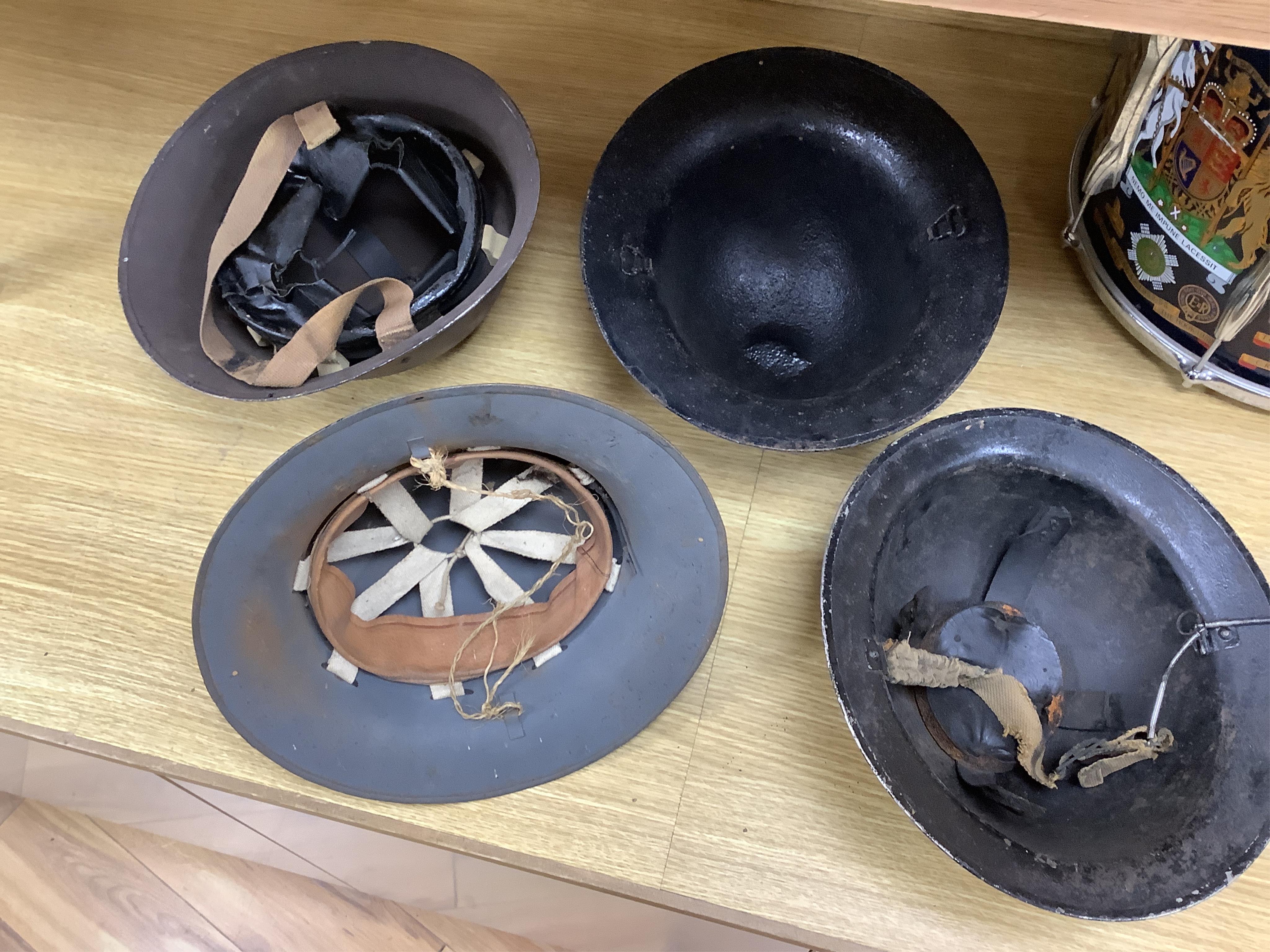 Seven early to mid 20th century military tin helmets; including one stencilled with POLICE. Condition - poor to fair.